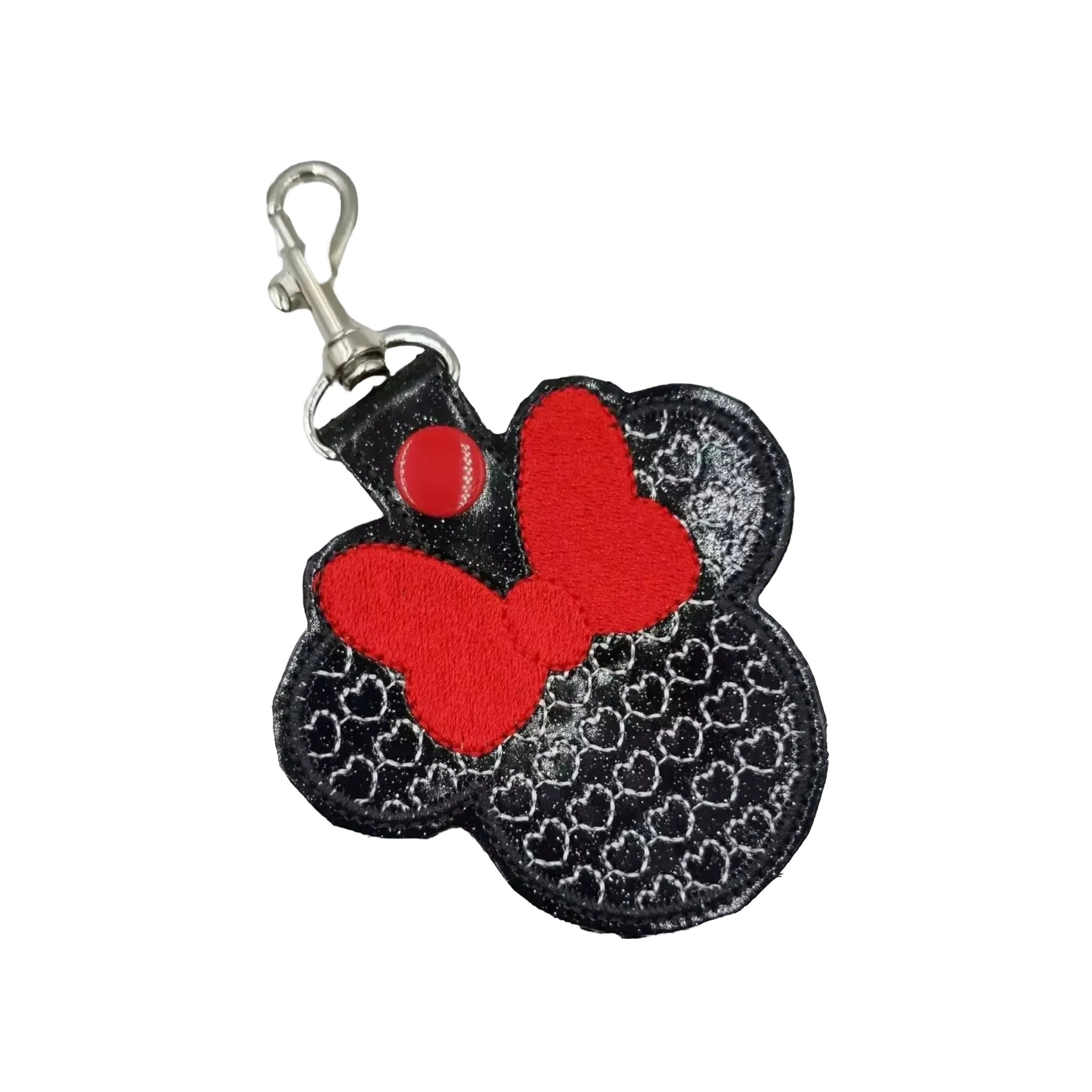 A black and red keychain with a red bow on top, designed to resemble a Minnie Mouse character.