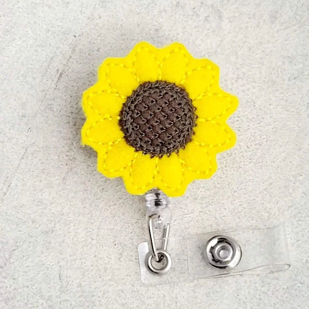 Sunflower embroidered felt badge reel with yellow petals and brown center for nurse ID holder
