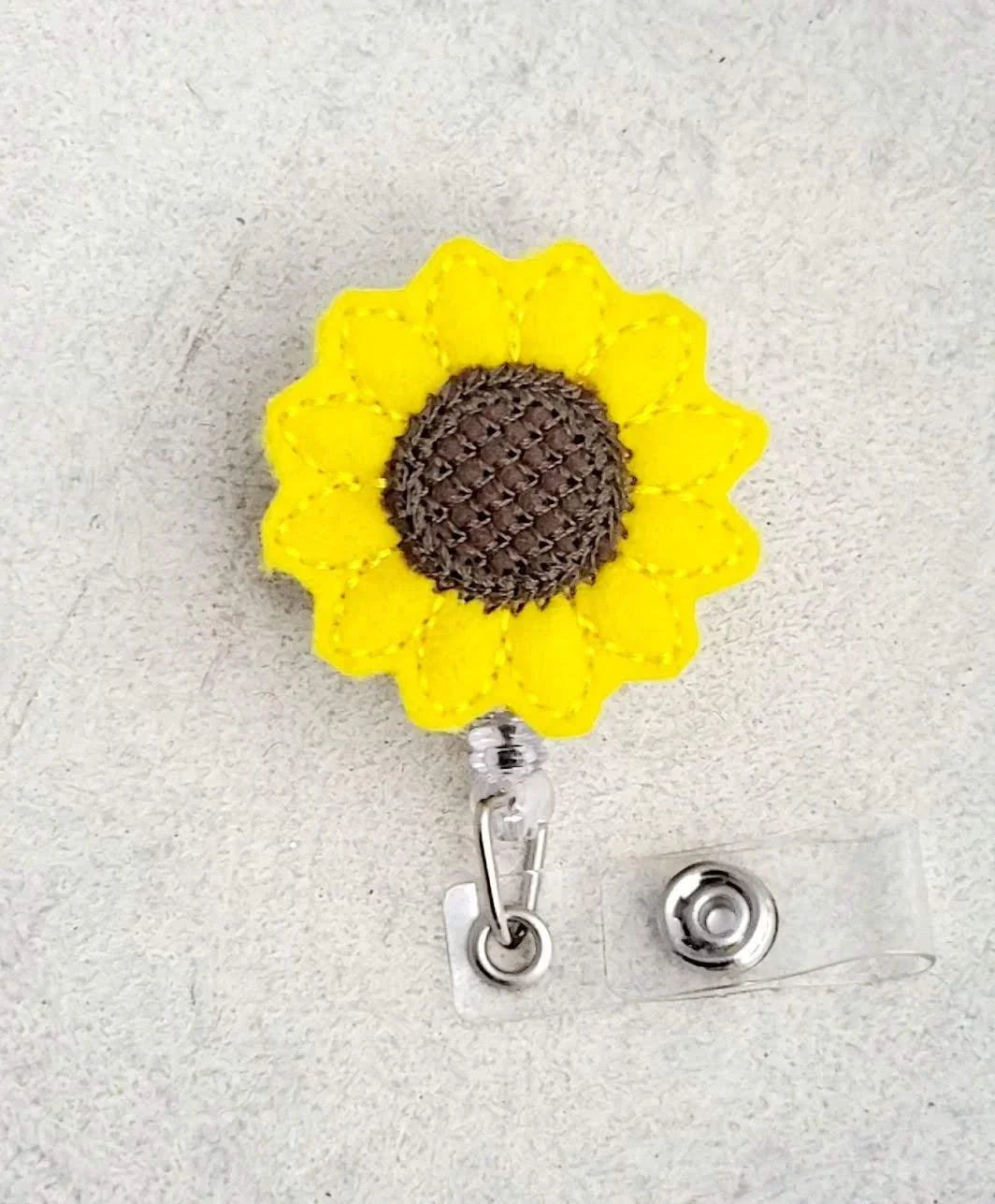 Sunflower embroidered felt badge reel with yellow petals and brown center for nurse ID holder