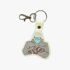 a keychain with an embroidered design depicting a person wearing a face mask.