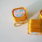 sardine Yellow container with a pink label on a white background